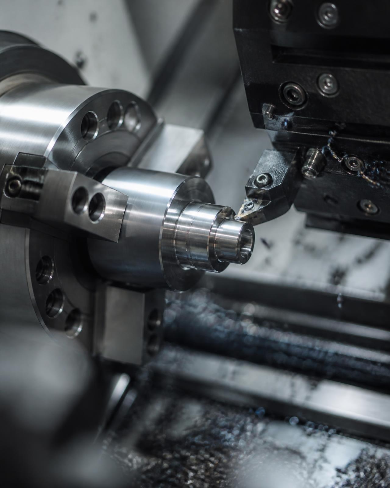 Tornio CNC che lavora un componente di precisione in acciaio